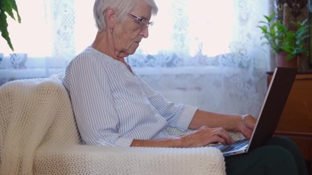 Felice anziana donna di mezza età sul computer portatile a lavorare sul lavoro d'ufficio. donna anziana digitando sul computer e acquista da shopping online. — Video Stock