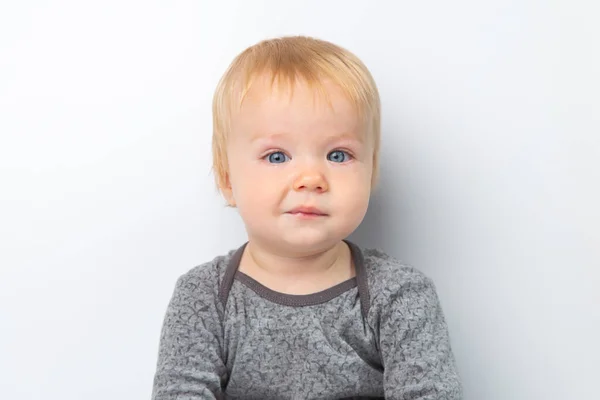 Enfant bébé garçon en chemise grise rit heureux en regardant la caméra isolée sur un fond blanc. Concept de garde et d "éducation des enfants. — Photo