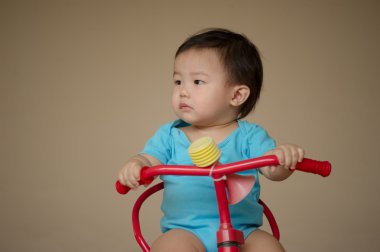 1 yaşındaki Çinli çocuk kırmızı bisiklet n tulumlardan sürme