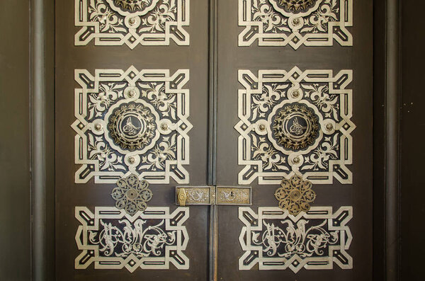 фрагмент двери в восточном стиле с орнаментом и арабской графикой