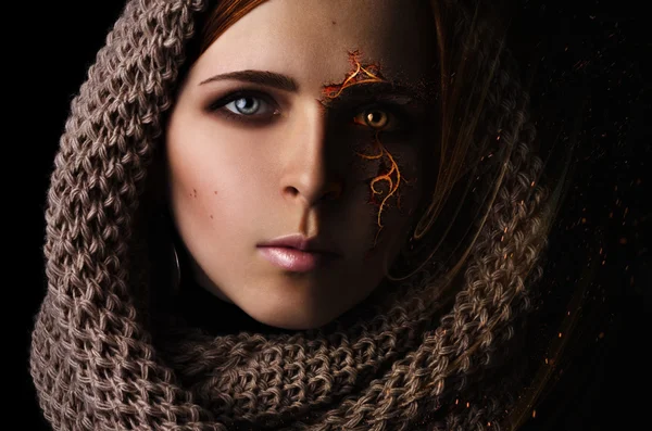 Fantasie verwerking portret van een jong meisje met een brandende patroon op het eerste gezicht in een sjaal op een zwarte achtergrond Rechtenvrije Stockafbeeldingen