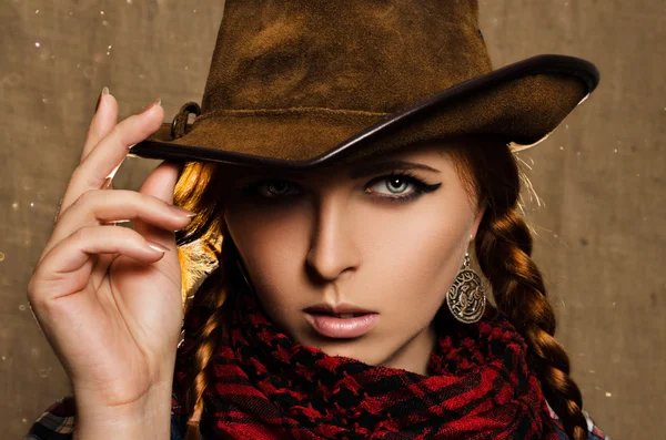 Porträtt av en vacker ung rödhårig flicka i en cowboyhatt Royaltyfria Stockfoton