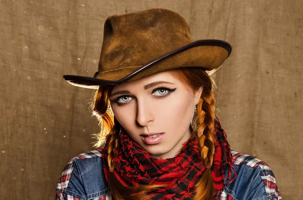 Porträtt av en vacker ung rödhårig flicka i en cowboyhatt Royaltyfria Stockfoton