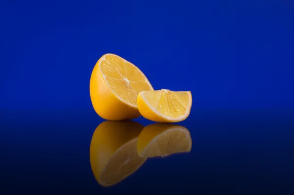 Limão sobre um fundo azul escuro com reflexão — Fotografia de Stock