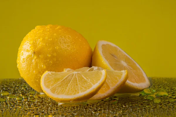 Sarı bir arka plan üzerinde su damla limon