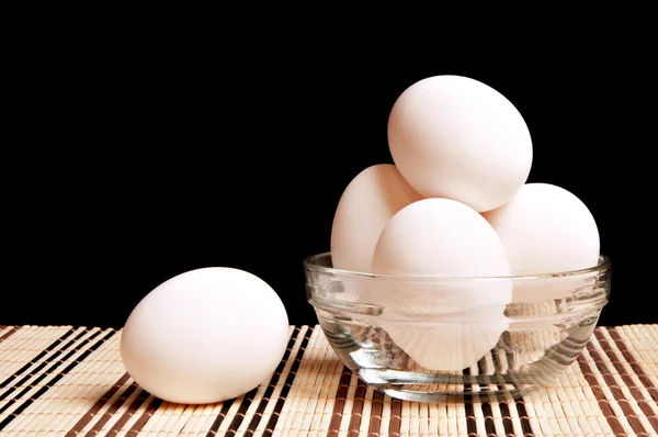 Куриные яйца на черном фоне — стоковое фото