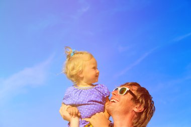 Baba ve küçük kız yaz göğün üzerinde oynama