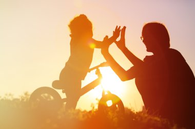 Baba ve kızı binicilik bisiklet gün batımında