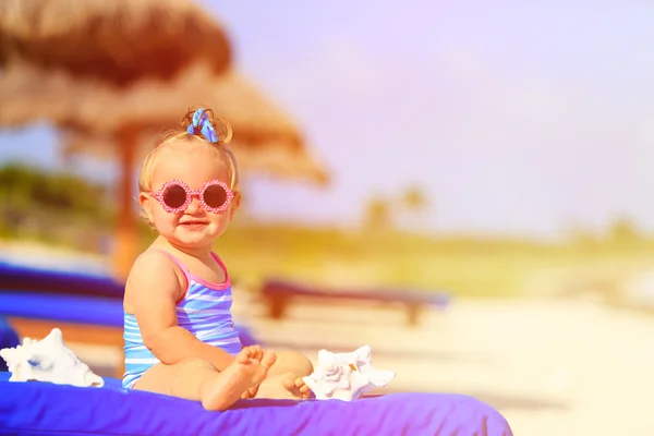 Mignonne petite fille avec coquillages sur la plage tropicale — Photo