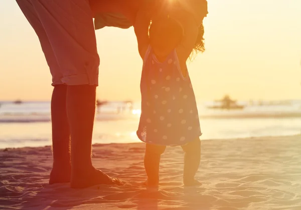 父亲和小女儿走在日落时的剪影 — 图库照片