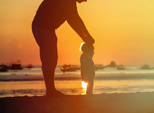 Silhouette de père et petite fille marchent au coucher du soleil — Photo