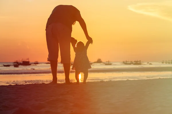 Silhouette di padre e figlioletta passeggiata al tramonto — Foto Stock