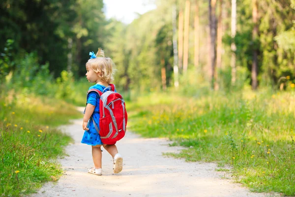 Menina bonito com mochila na floresta de verão — Fotografia de Stock