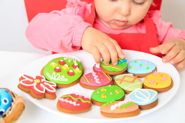Liten flicka leker med påsk cookies — Stockfoto