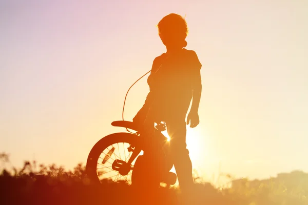 Menino andando de bicicleta ao pôr-do-sol, crianças esporte — Fotografia de Stock