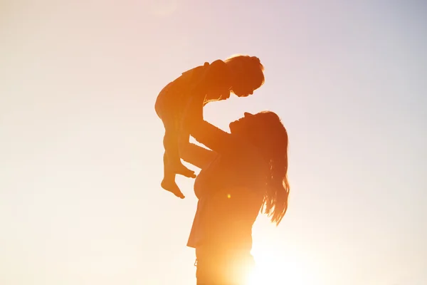 Mother and little daughter play at sunset — Stock Photo, Image