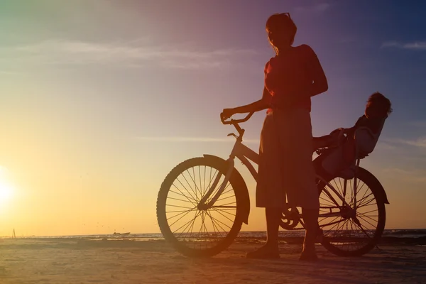 Silueta de la madre y el bebé en bicicleta al atardecer —  Fotos de Stock