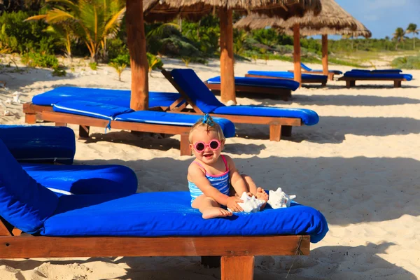 Schattig klein babymeisje met schelpen op tropisch strand — Stockfoto