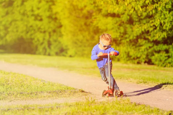 Kis fiú lovaglás scooter nyári Park — Stock Fotó