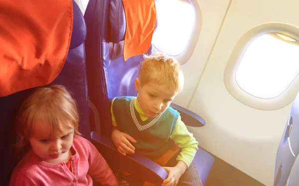 Niño y niña viajan en avión — Foto de Stock
