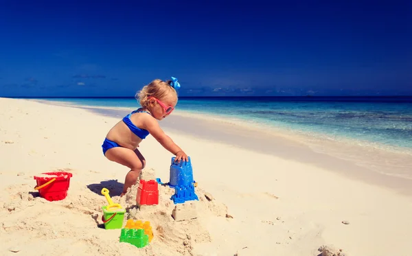 Carino bambina che gioca con la sabbia sulla spiaggia — Foto Stock