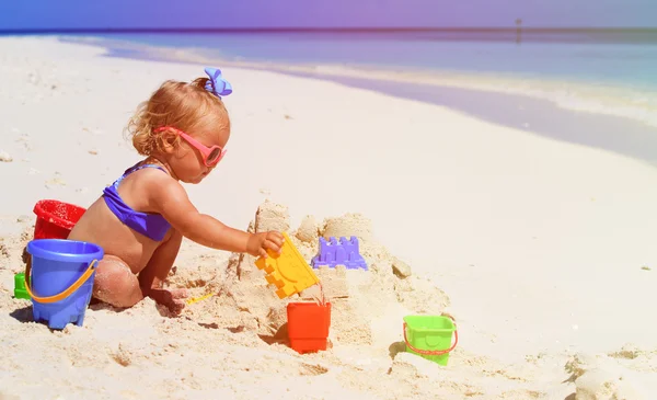 Cute little girl playing with sand on beach — Stock Photo, Image