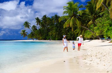 Kumsalda oynayan çocuk ile aile