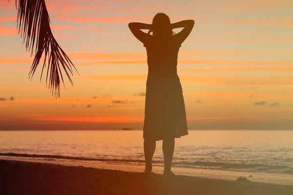 Kvinna njuta solnedgången på tropical beach — Stockfoto