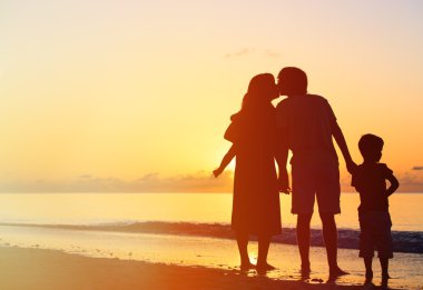 Romantik Çift çocuklarla günbatımında öpüşme.