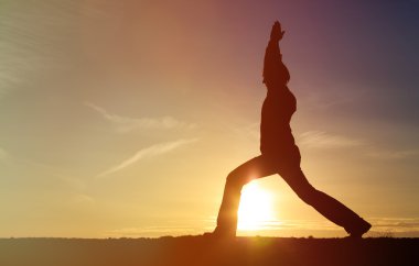 günbatımı gökyüzü Yoga yapan genç erkek