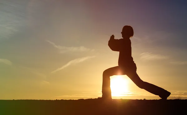 Молодий чоловік робить йогу на заході сонця небо — стокове фото