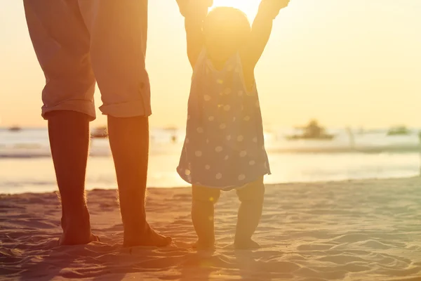 Silhouet van vader en dochtertje op strand — Stockfoto