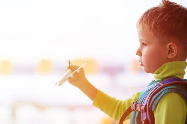 Kleiner Junge spielt mit Spielzeugflugzeug im Flughafen — Stockfoto