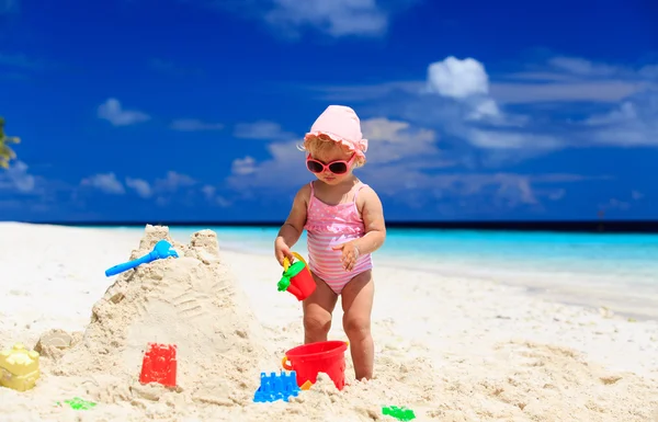 Schattig klein meisje gebouw sandcastle op strand — Stockfoto