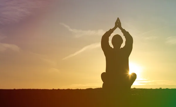 Joven haciendo yoga al atardecer cielo — Foto de Stock