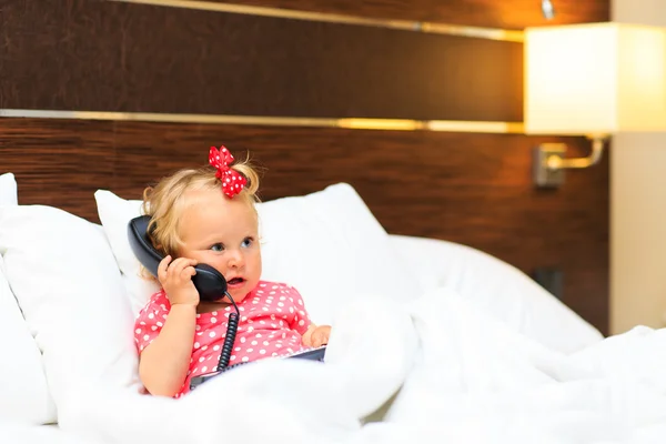Söt liten flicka tar på telefonen i hotel — Stockfoto
