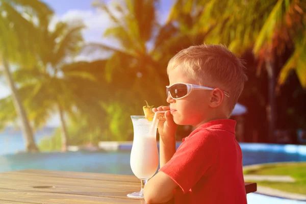 Piccolo ragazzo bere cocktail sulla spiaggia tropicale — Foto Stock
