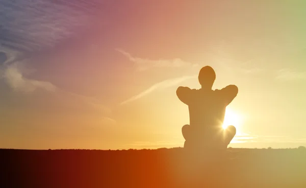 Молодий чоловік робить йогу на заході сонця небо — стокове фото
