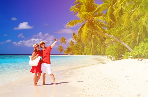 Молодая счастливая пара делает селфи на пляже — стоковое фото
