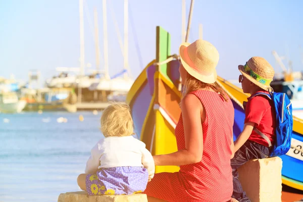 Mãe e duas crianças olhando para barcos tradicionais em Malta — Fotografia de Stock