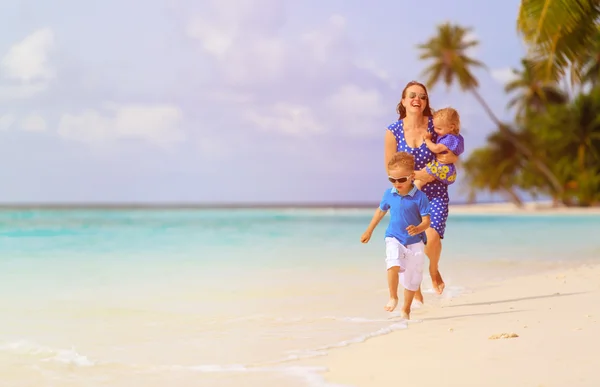 Niño feliz con la madre y la hermana corriendo en la playa —  Fotos de Stock