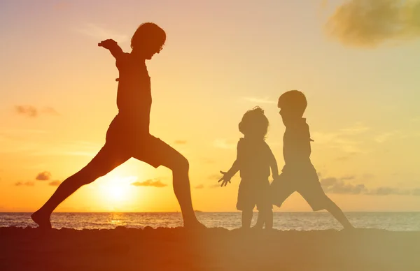 Padre con i bambini sagome divertirsi al tramonto — Foto Stock