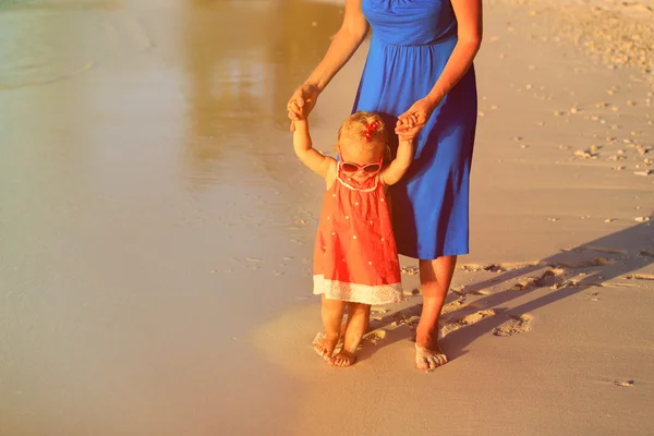 Moeder en dochtertje wandelen op het strand — Stockfoto