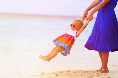 Anne ve tropik sahilde oynarken kızım