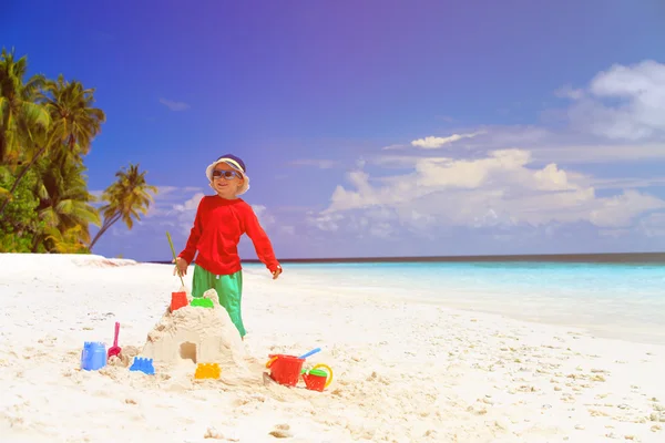 Malý chlapec, budování hrad z písku na pláži — Stock fotografie