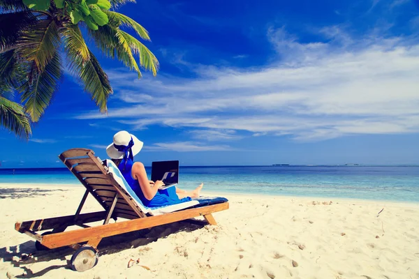 Młoda kobieta z laptopa na tropikalnej plaży — Zdjęcie stockowe