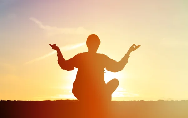 Homem fazendo ioga no céu por do sol — Fotografia de Stock