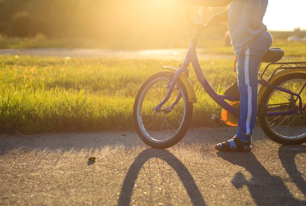Bambino in sella alla bicicletta al tramonto — Foto Stock