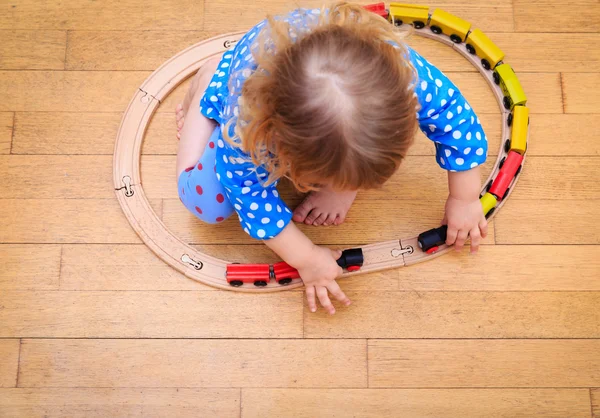 Μικρό κορίτσι παίζει με τρένα εσωτερική — Φωτογραφία Αρχείου