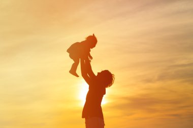 Baba ve küçük kızı siluetleri gün batımında